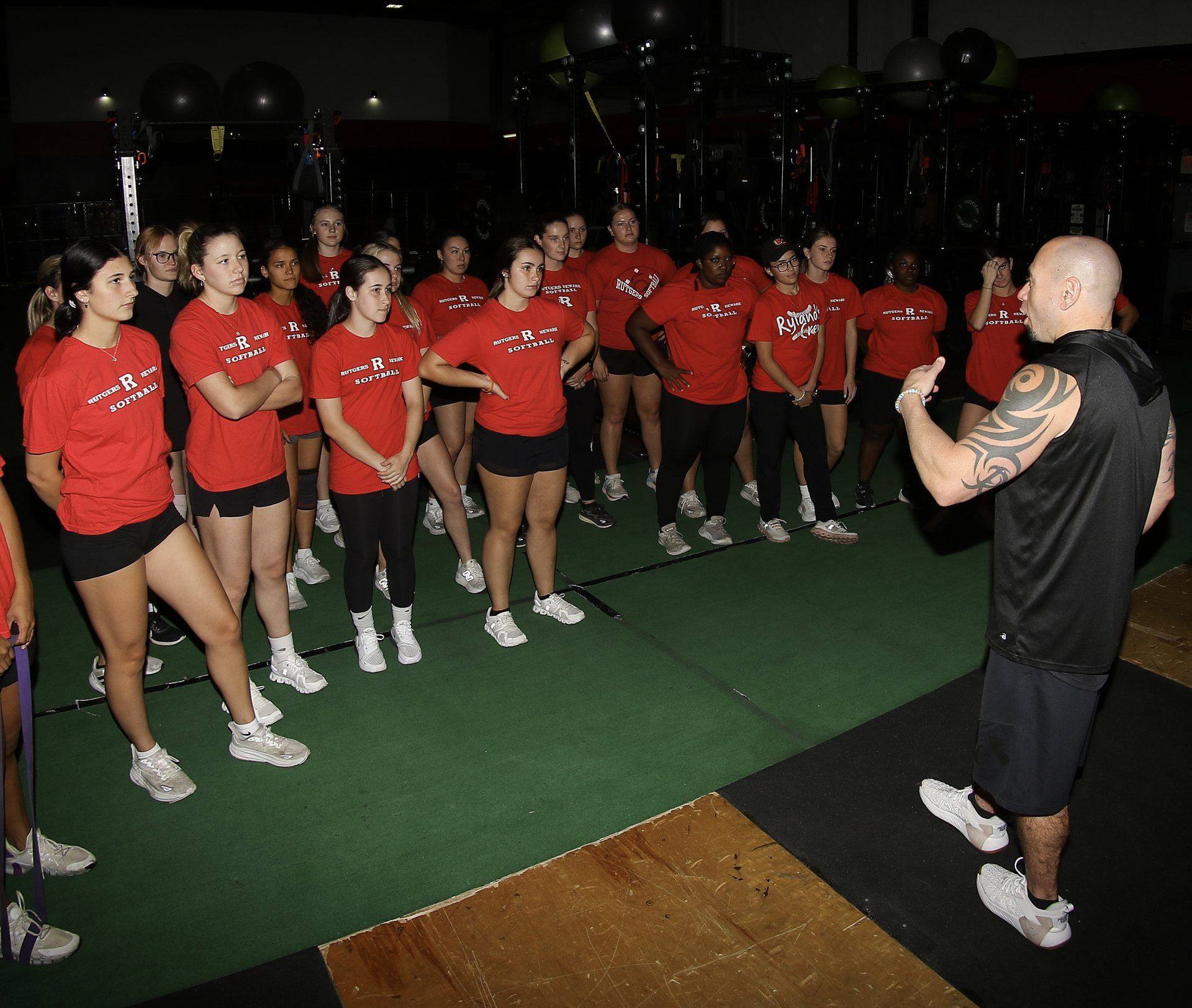 A full team of Rhino Den athletes training together on the turf floor with their coach